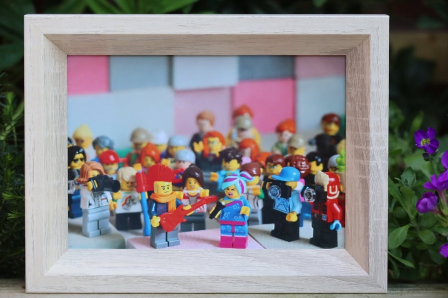Framed Lego figures, Flashback Lucy sings everything is awesome to her fans.