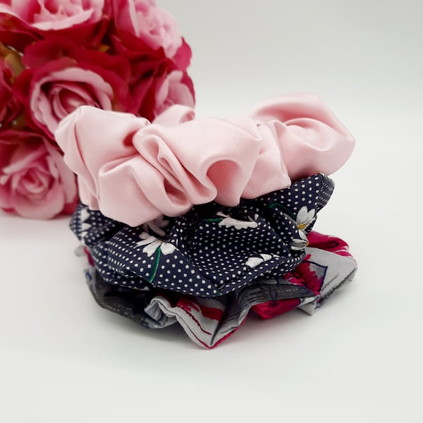 Stack of 3 scrunchies,  navy polkadot,  pink satin and grey raspberry pink. 