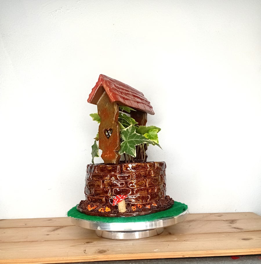 Ceramic hand made wishing well planter indoor.