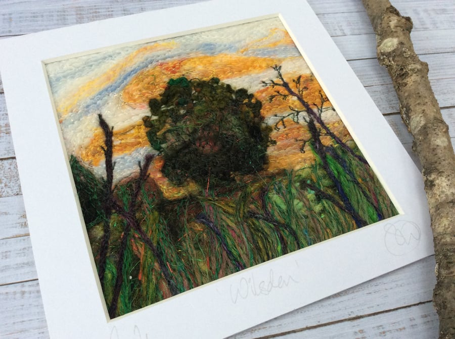 Embroidered needle felted sunset countryside scene with tree and plants. 