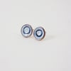 Round copper stud earrings with blue and white enamel and drawn detail.