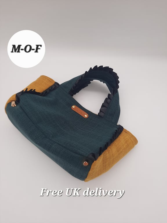 Small handbag in forest green and mustard yellow with black ribbon trim.