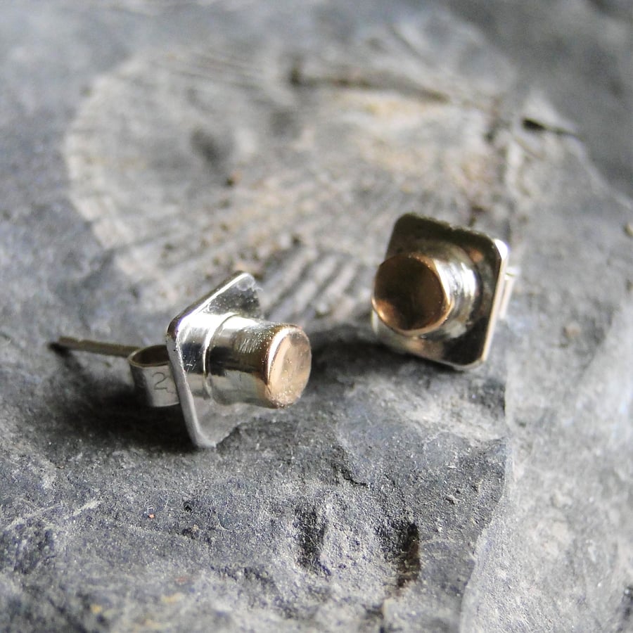 Silver stud earrings with a gold accent