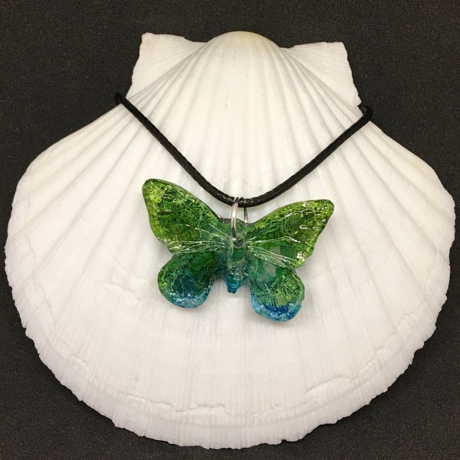 Green and blue butterfly resin and ink necklace.