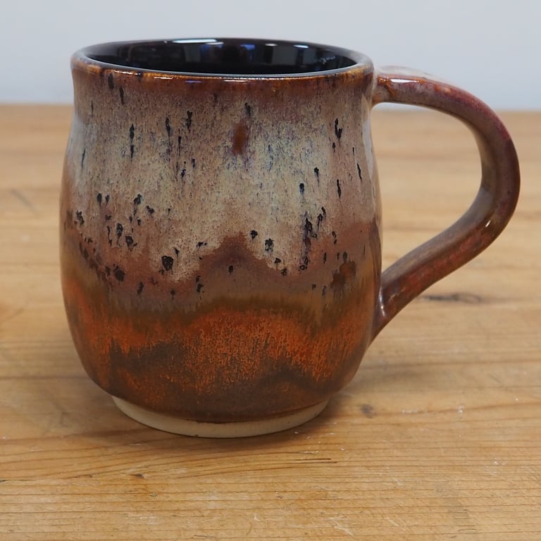 Large stoneware pottery mug finished in multi-coloured purple and copper glaze.