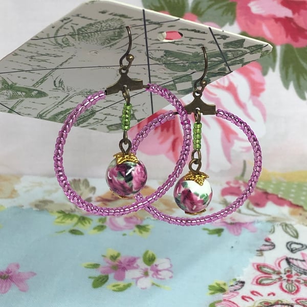 Pink glass hoop earrings with floral porcelain beads