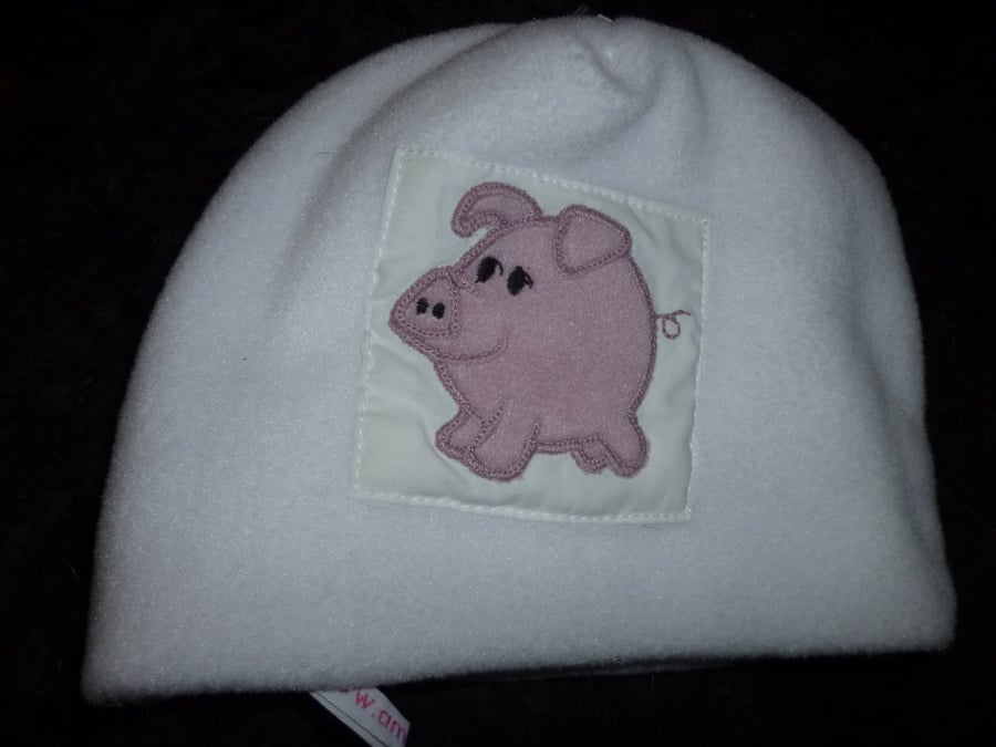 Baby hat with pig applique on white fleece 