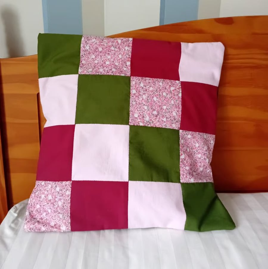 Patchwork cushion cover in olive green, crimson and pink. 