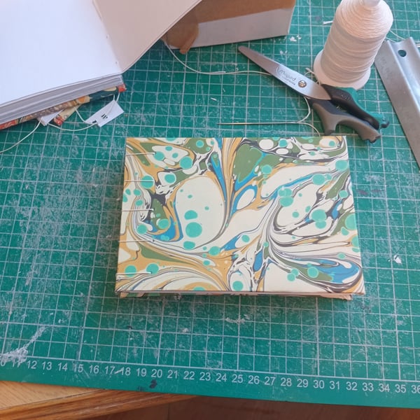 A6 portrait indian cotton paper sketchbook.  Smooth texture,  Coptic stitch.