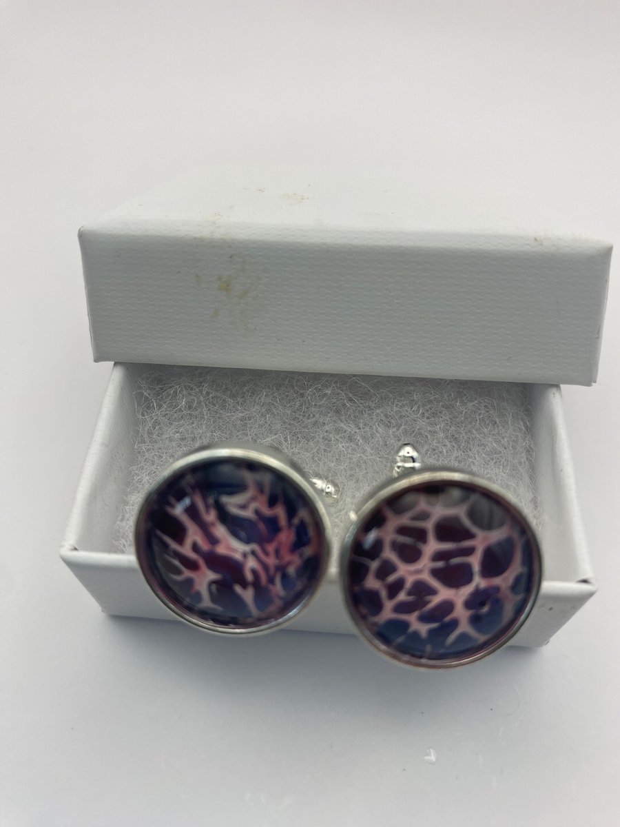 Pair of cuff links with pink and purple pigments 