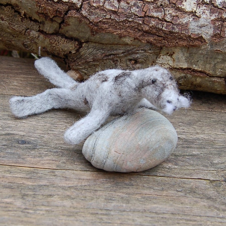 Basking grey seal .  Needle felt seal attached to a found pebble
