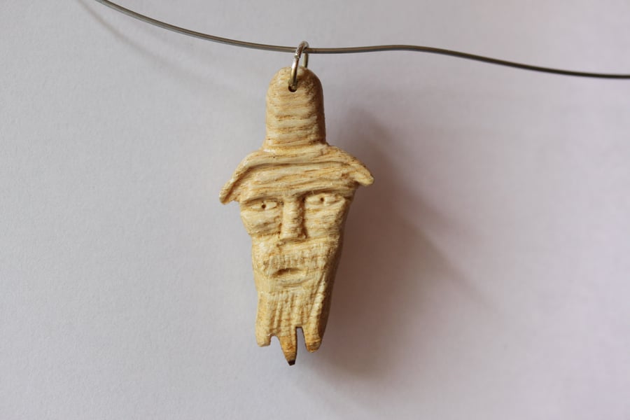pendant:- carved head of a man
