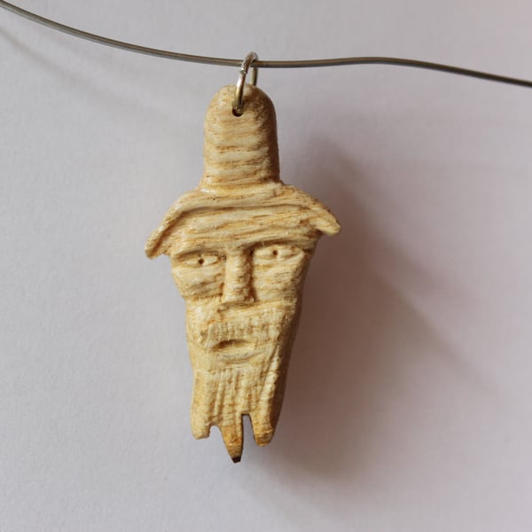 pendant:- carved head of a man