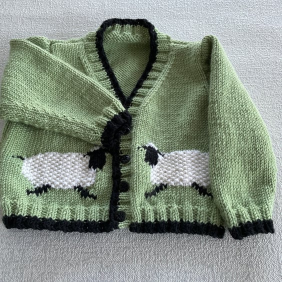 Green baby cardigan with sheep designs on the front