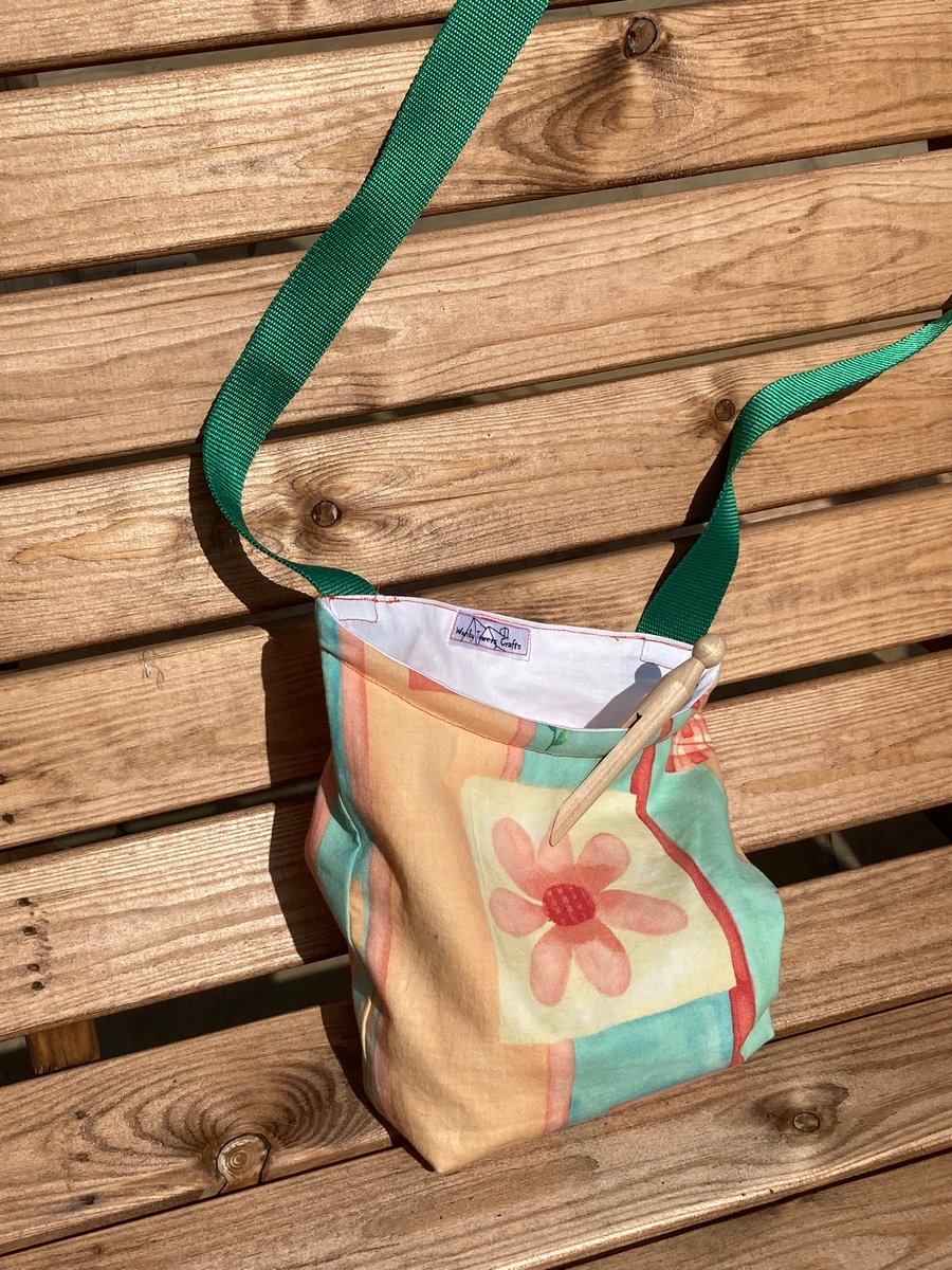 Peg bag with green shoulder strap for easy laundry hanging. Peaches and green.