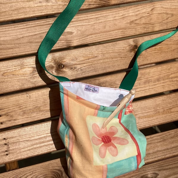 Peg bag with green shoulder strap for easy laundry hanging. Peaches and green.