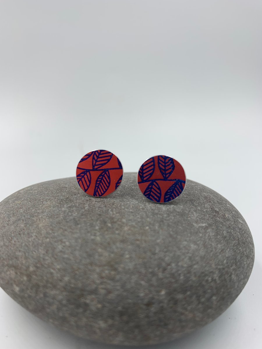 Red aluminium circle stud earrings with leaf print
