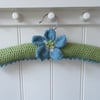Hand knitted padded coat hanger with knitted anemone flower