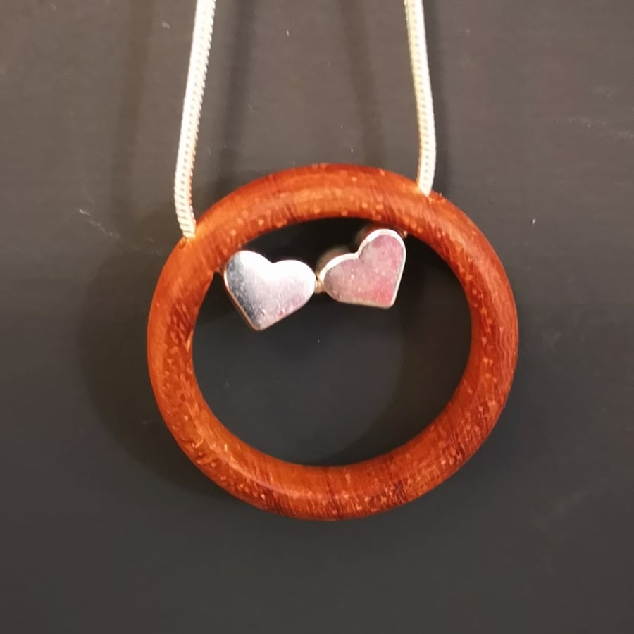 WOODEN PENDANT WITH TWO SILVER HEART CHARMS