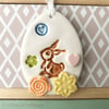 Pottery Easter Egg decoration with bunny in the flower meadow 