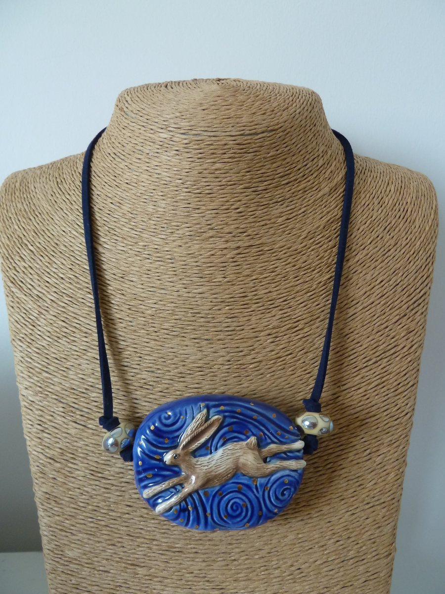 blue faux suede necklace with lampwork glass and ceramic hare pendant