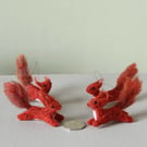 Wee red squirrels leaping -dark red