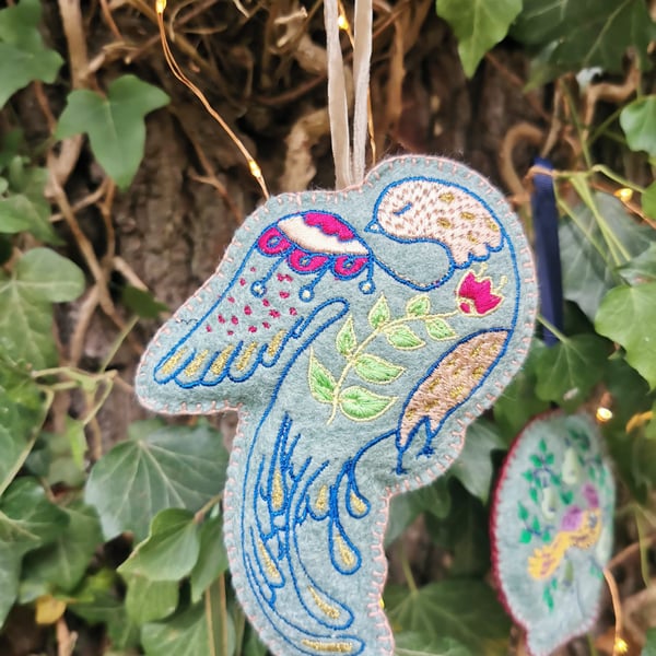Embroidered modern folk bird on felt fabric. With a hanging ribbon, a lovely Chr
