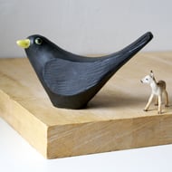 Handmade ceramic blackbird sculpture with a curious pose
