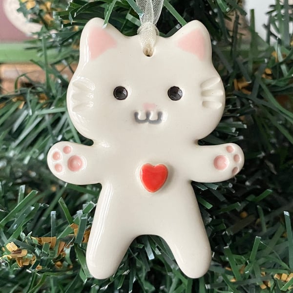 Small white pottery cat decoration with red heart