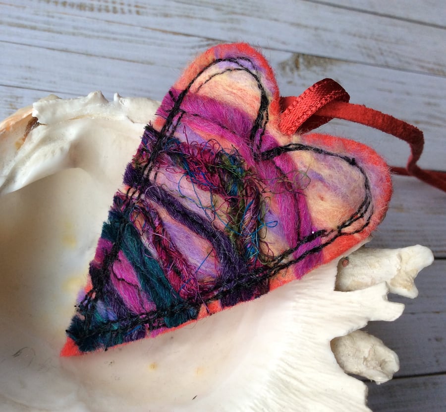 Strikingly colourful wool heart necklace.