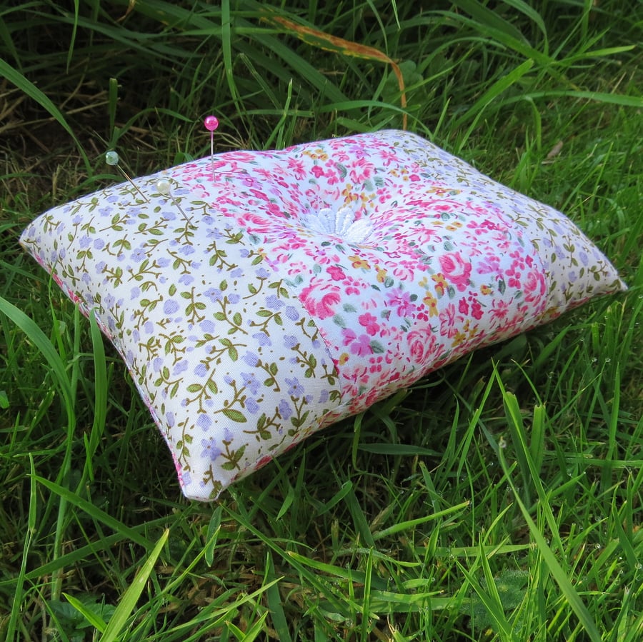 A chintzy floral pin cushion.