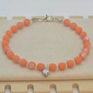 Orange Czech glass bracelet with a silver heart charm 