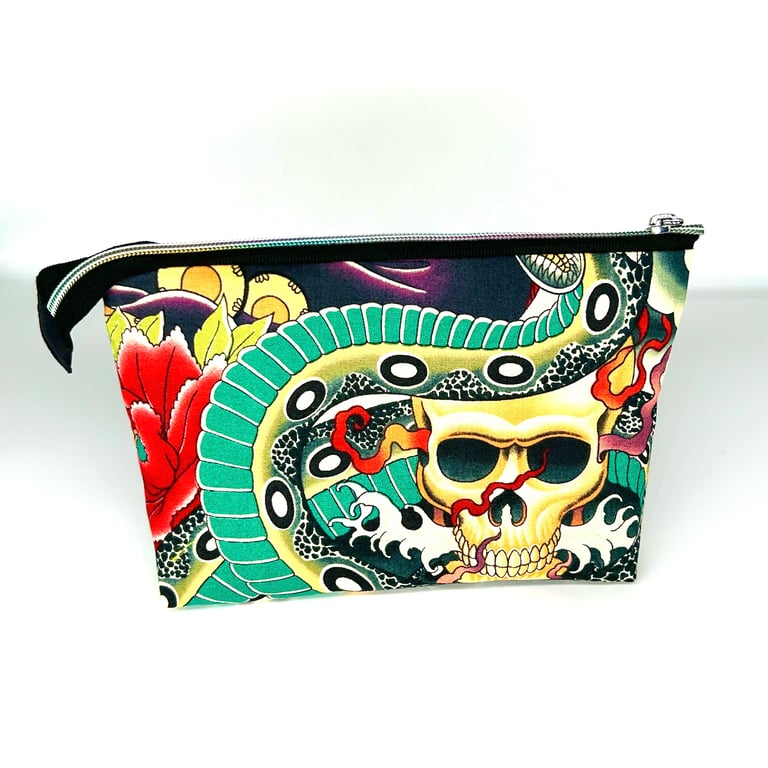 Cosmetic bag with tattoo style print and roses lined with black fabric.