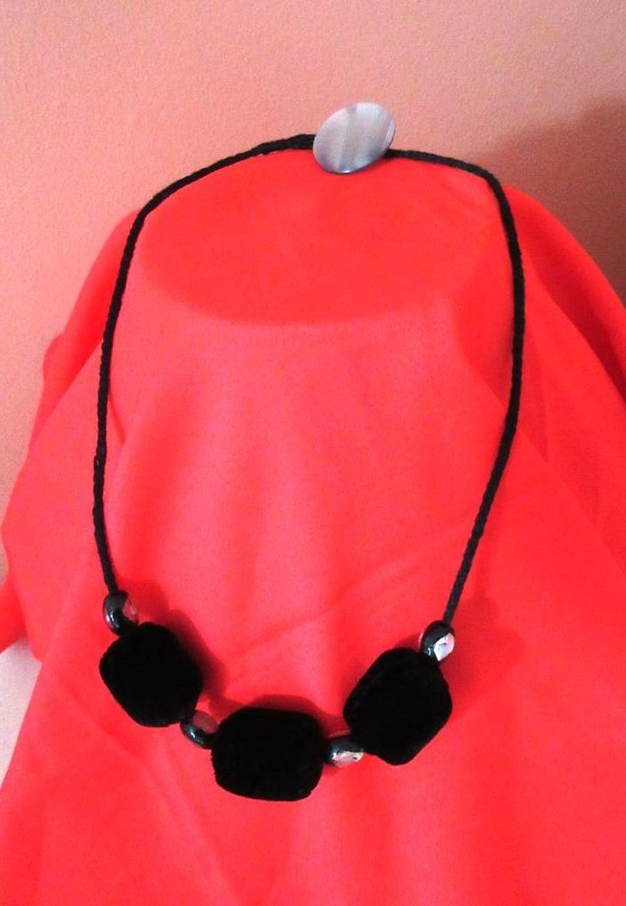 A fabric bead necklace in black velvet with glass bead spacers knitted I-cord