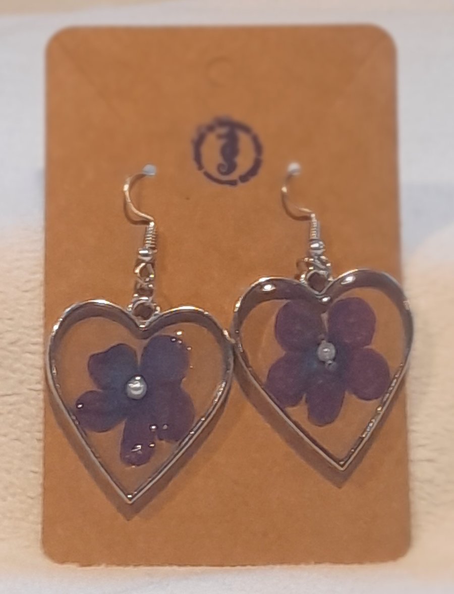 Heart shaped resin earrings with purple flower inclusion