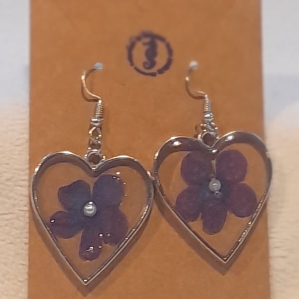 Heart shaped resin earrings with purple flower inclusion