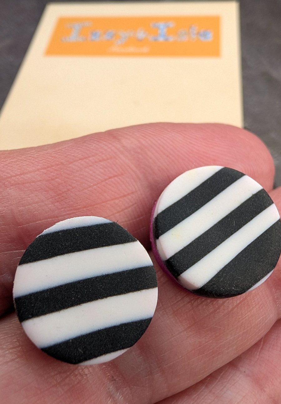 Monochrome striped stud earring with a hot pink accent.