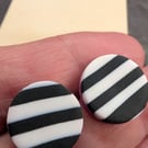 Monochrome striped stud earring with a hot pink accent.