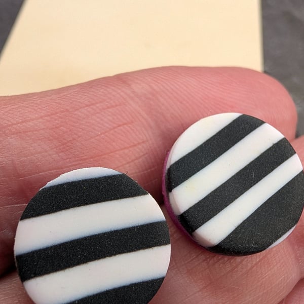 Monochrome striped stud earring with a hot pink accent.