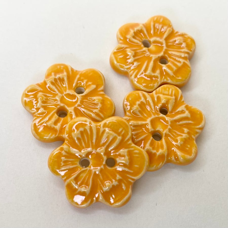 Set of four little handmade ceramic flower buttons orange