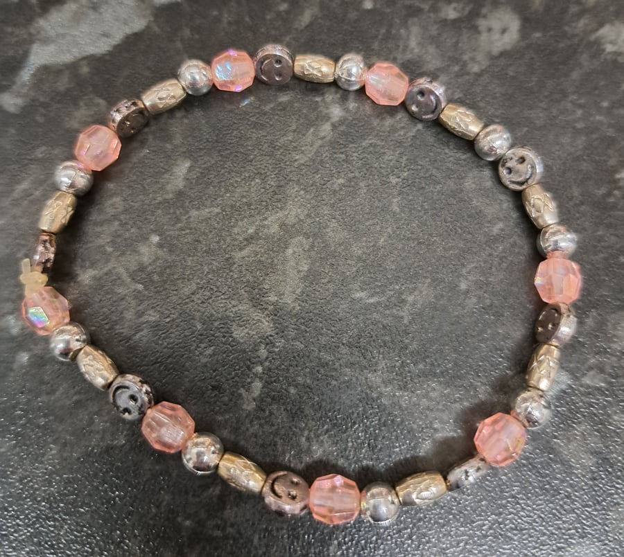 Beaded elasticated bracelet, pink with silver plated spacers, smileys