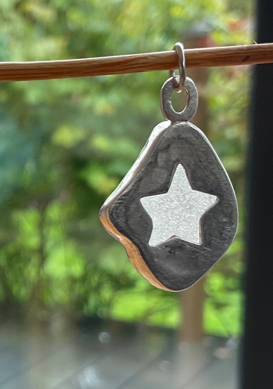 White seaglass mounted in stirling silver with a cute star cut out