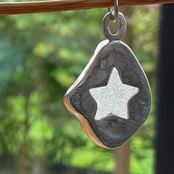 White seaglass mounted in stirling silver with a cute star cut out