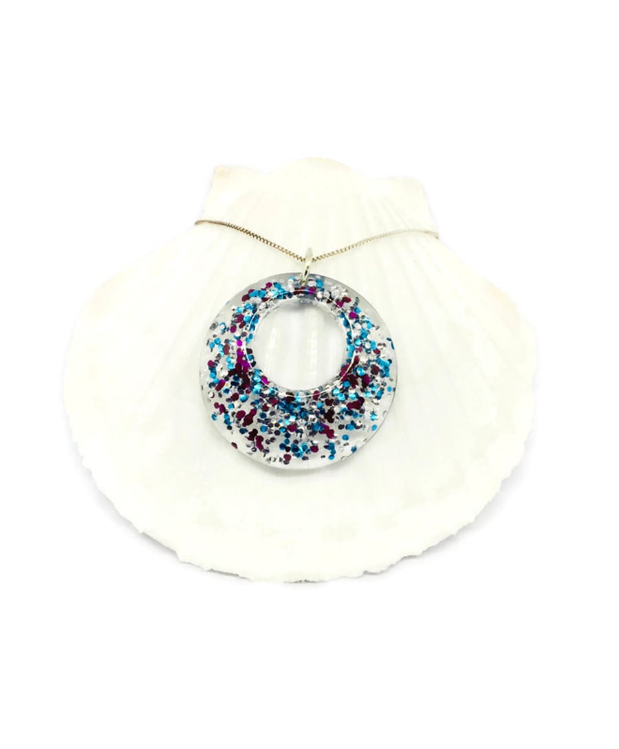 Sparkly donut necklace claret, blue and silver sparkles encased in resin.