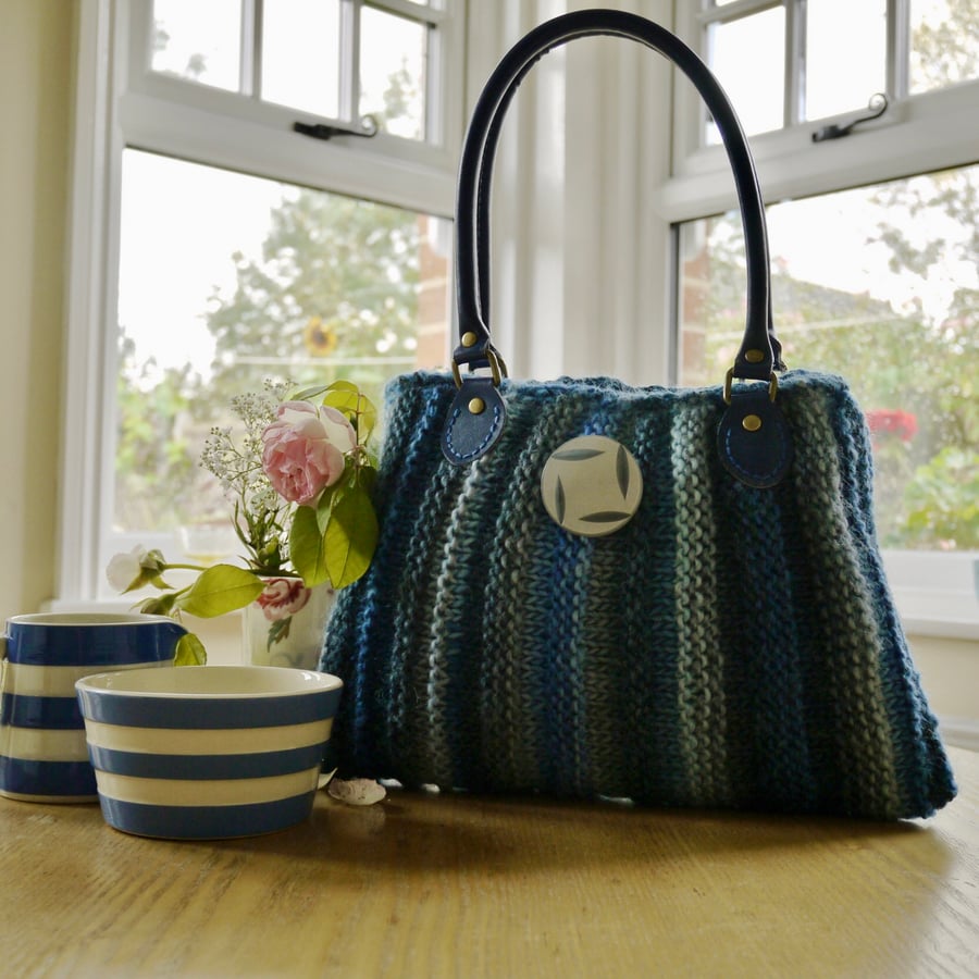 Stripey blue knitted woolly purse bag with leather handles.