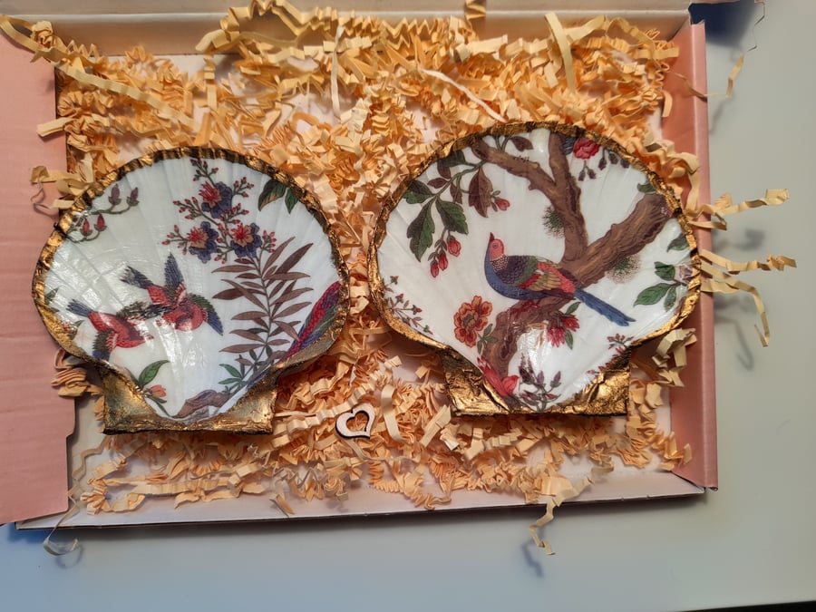 Scallop shells with decoupaged bird designs.