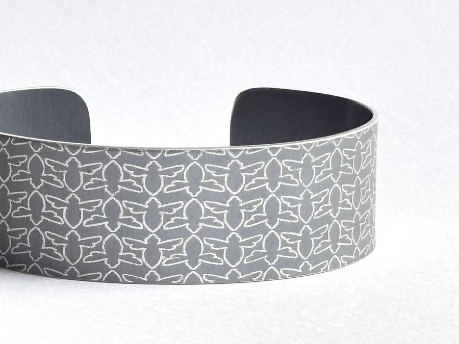 Grey aluminium cuff with bee pattern