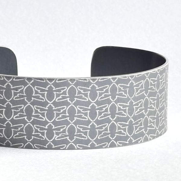 Grey aluminium cuff with bee pattern
