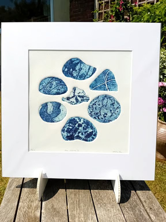A collagraph print of beach pebbles blue