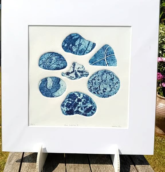 A collagraph print of beach pebbles blue